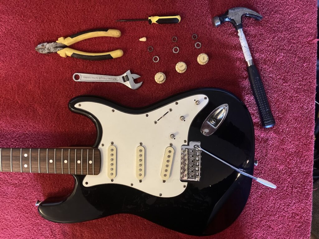 body of Stratocaster with the retaining nuts for the volume and tone potentiometers removed