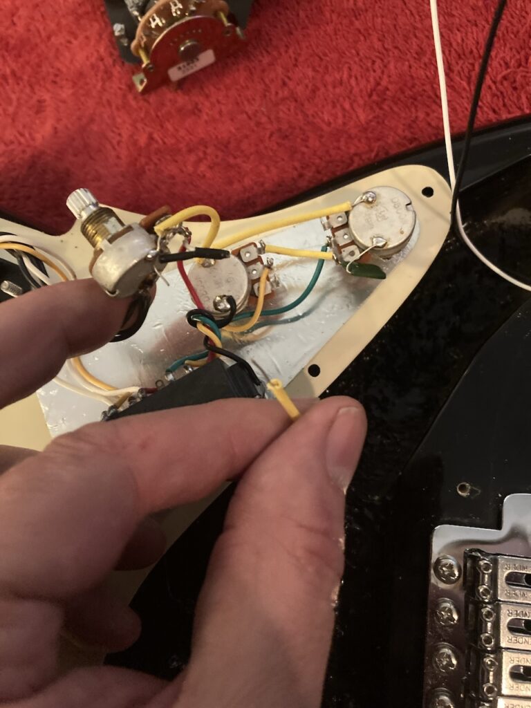 The ground wire leading to the claw at the back of the guitar and the protecting sleeve, severed