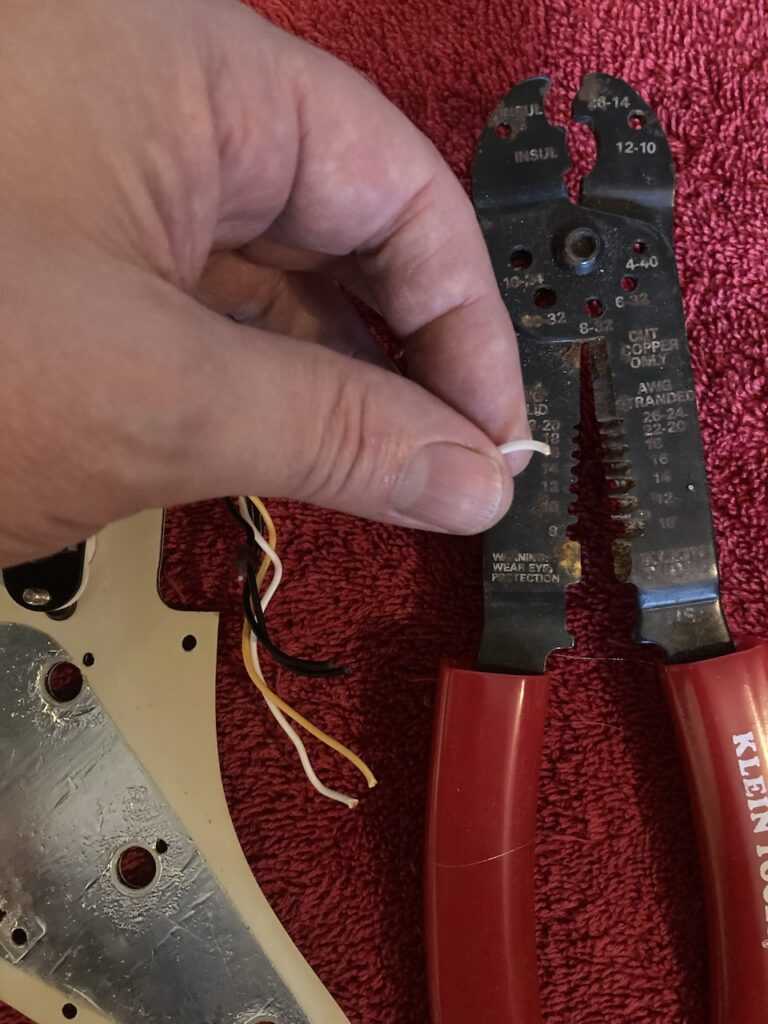 A wire being stripped using a wire stripper tool