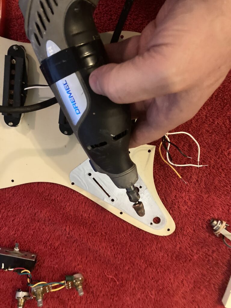 A Dremel tool with parabolic sanding tip to enlarge the holes