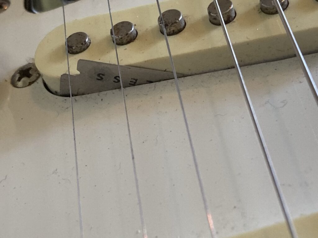 A razor blade sticking out the guitar body alongside one of the pick-ups